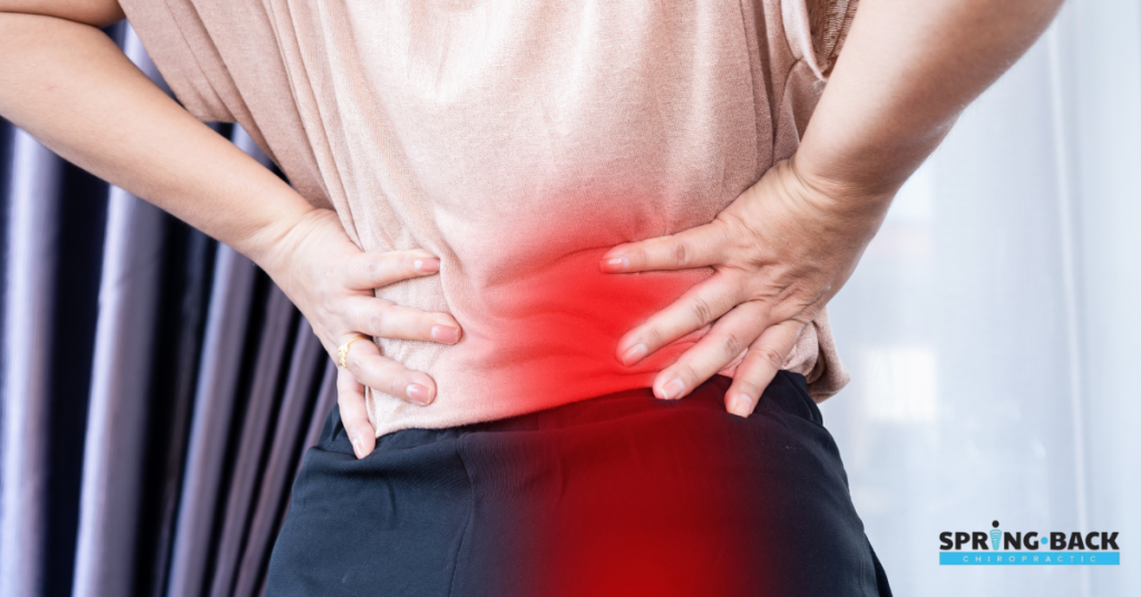 Person holding lower back in pain
